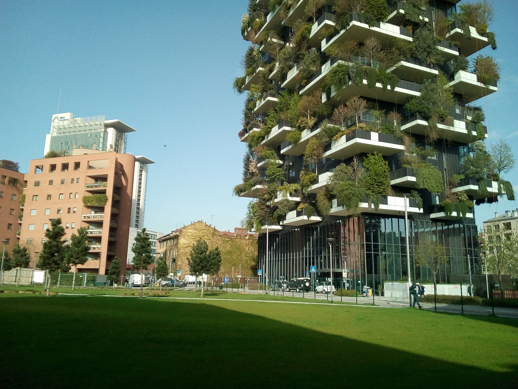 Open space luminoso nei toni dell'azzurro e ottanio, con una piccola cucina bianca integrata e un elegante tavolo da pranzo rotondo